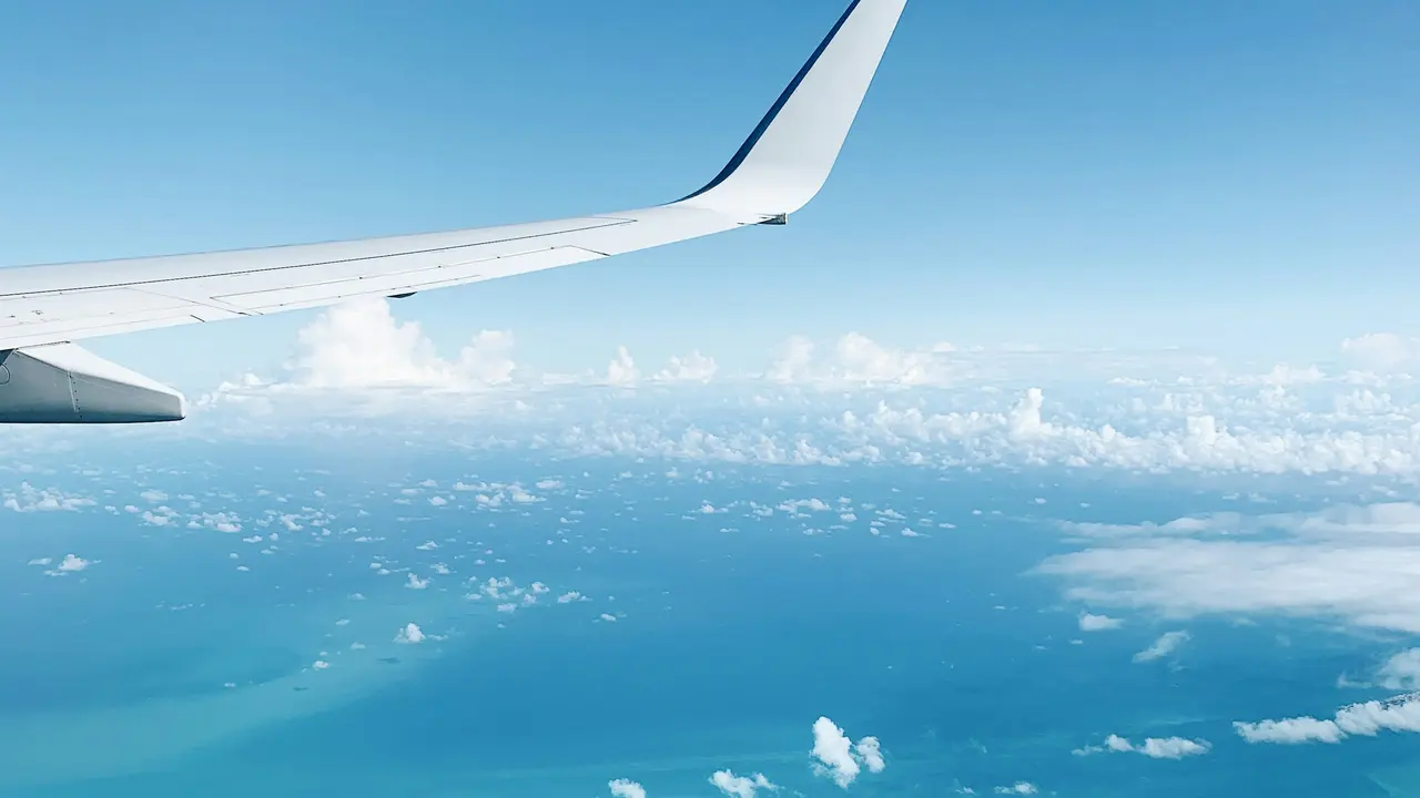 Airplane wing over the turquoise sea on arrival in Cancún